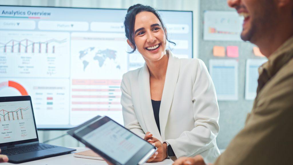 Smiling Business woman discussing with developers is meeting to review the data analysis of marketing from social media platforms.